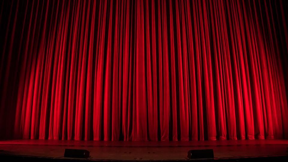 Stage with red curtains. Image CC via Flickr. 