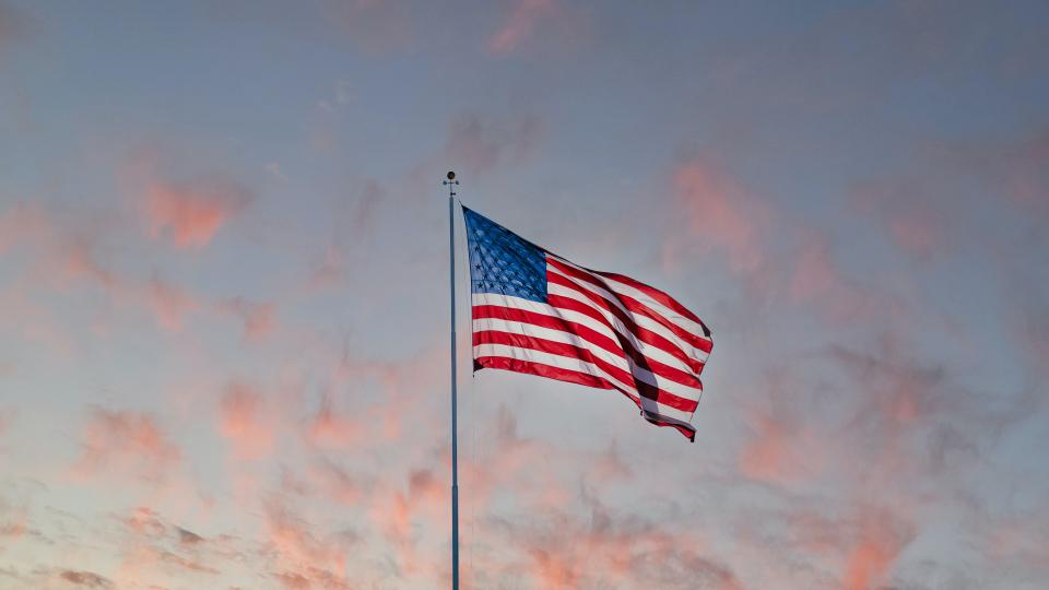 US flag on Wall Street. Photo via Unsplash.